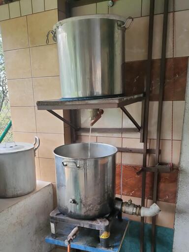 My brewing setup, 2 big pots one above the other with wort pouring to the lower one.