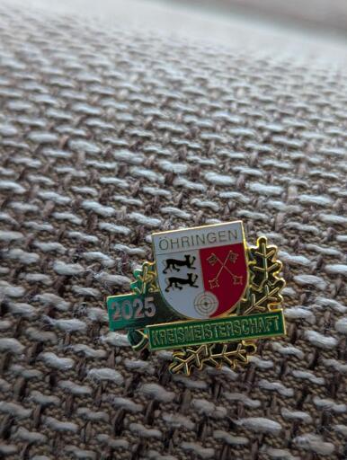 A golden pin that shows the flag of the county Öhringen. It reads "2025 Kreismeisterschaft“.