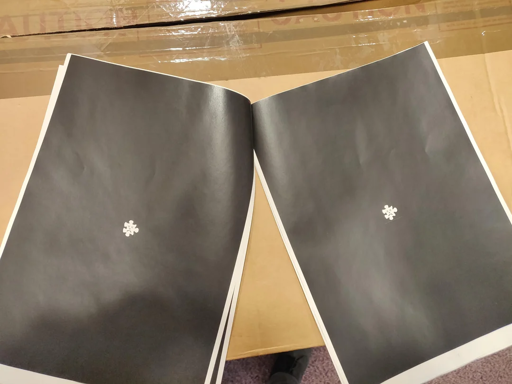 Some sheets of paper which are printed black, with a small broken jigsaw piece in it.