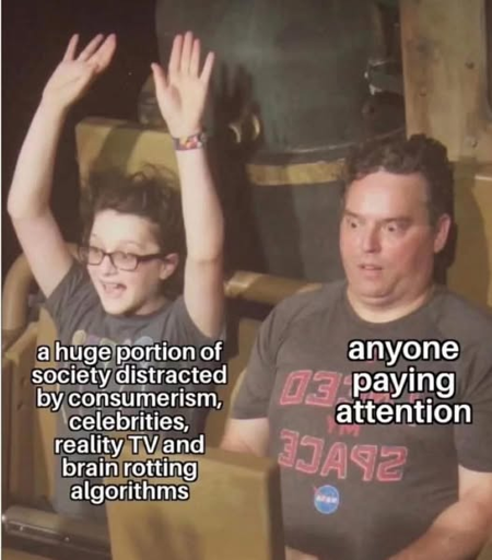 A picture of a young boy and a middle-aged man on a roller-coaster in motion. The boy is enthusiastic, with his arms in the air. The man has a horror-stricken look on his face as he appears to look at what's ahead on the ride.   Meme-text is written on their bodies.   The text on the boy says "a huge portion of society distracted by consumerism, celebrities, reality TV and brain rotting algorithms."   The text on the man says, "anyone paying attention"