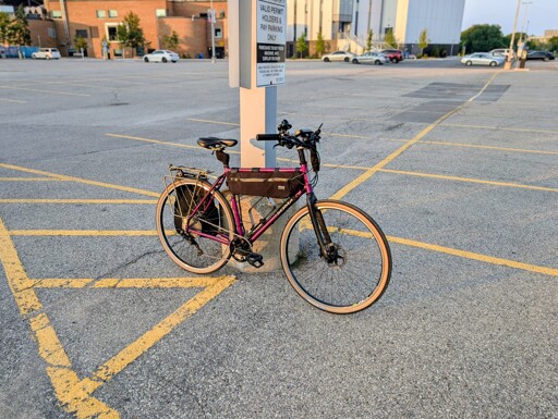 A photo of a bicycle with a purple frame, black fork and tires with tan sidewalls