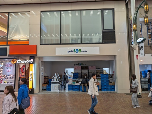A storefront named "IkuRō 196 Marche". The 196 is written in blue and green. The store is located in a Japanese sorta shopping street thingy
