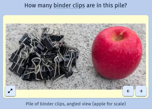 A screenshot of the daily game Estimate Me showing a picture of a pile of binder clips next to an apple